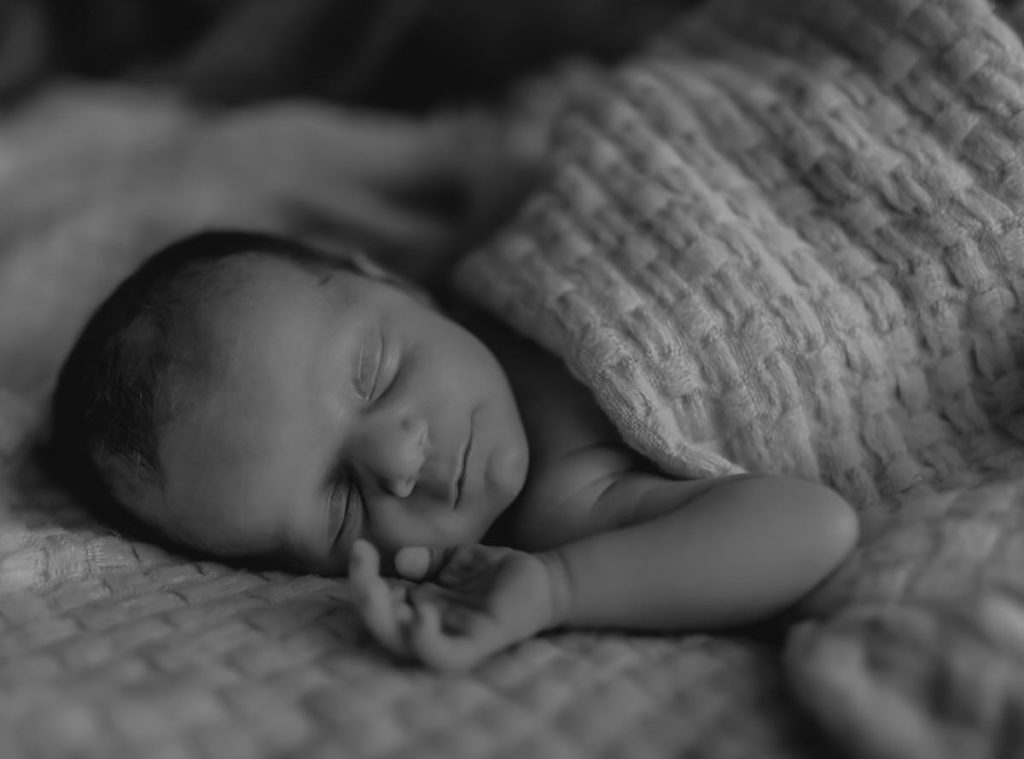 black and white photo of sleeping newborn