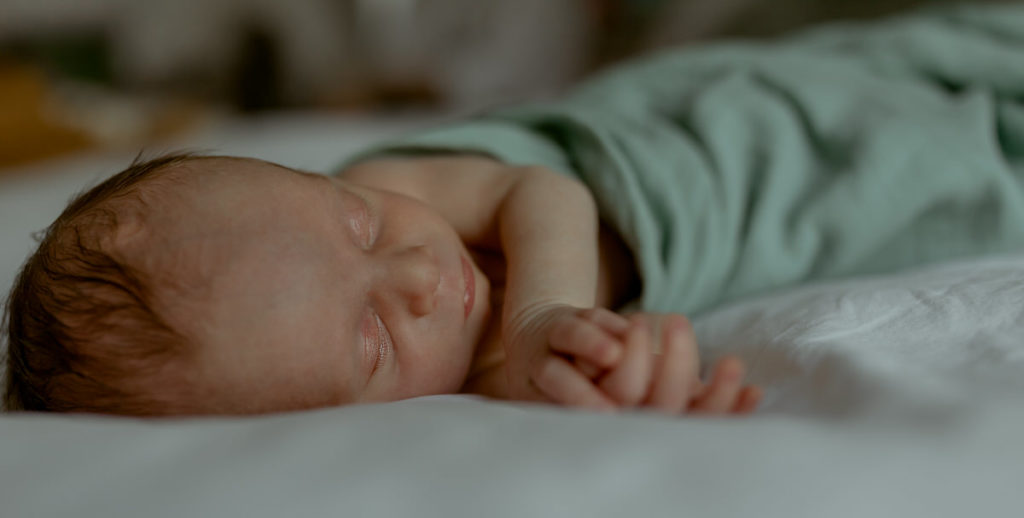 Close up of newborn sleeping on bed 