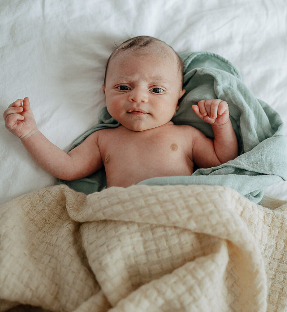 NYC in home family newborn session, newborn in a cream colored blanket.