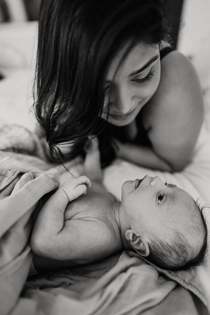 black and white image of mom on bed with her newborn son taken in The West Village, NY.