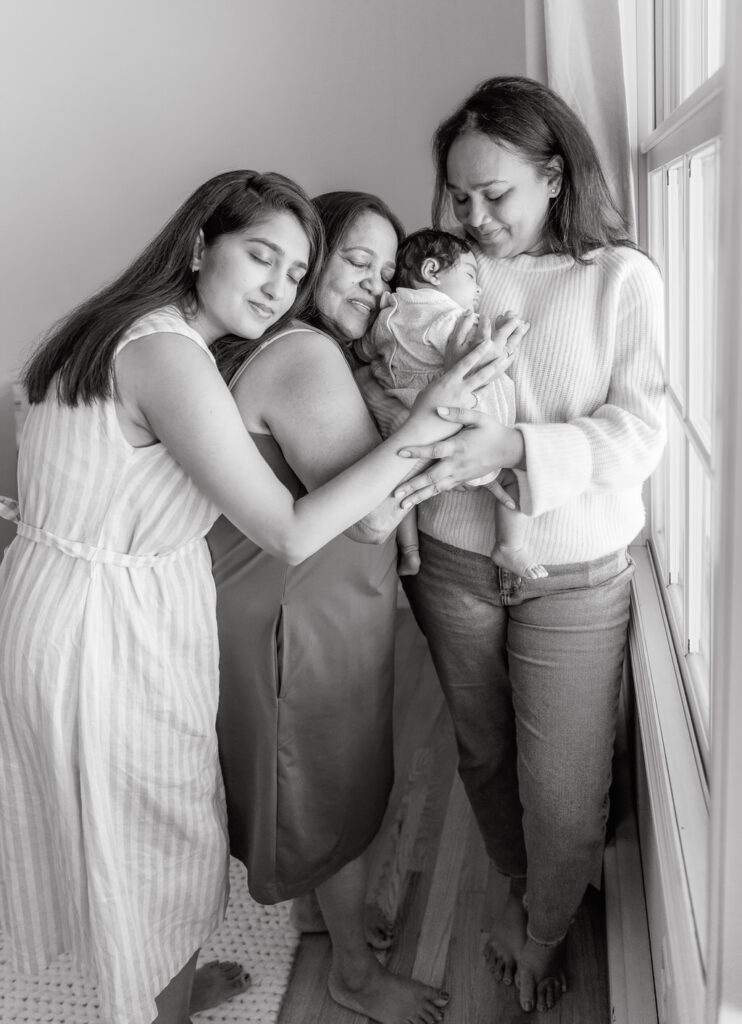 long island newborn mother, grandmother and sister holding their baby girl.